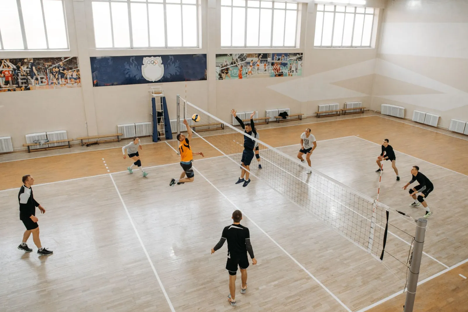 High-energy indoor volleyball game with teams competing intensely on the court.